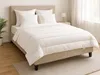 A neatly made bed with white bedding in a bedroom setting. Náhľad obrázku produktu