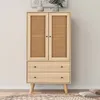 A light wood cabinet with rattan doors and two drawers, set against a neutral wall. Anteprima dell’immagine prodotto