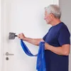 An older man is performing a physical therapy exercise using a blue resistance band attached to a door. Voir les images du produit