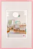 A pink picture frame containing an image of a home office/living space. Voir les images du produit