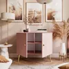 A pink two-door cabinet with shelves, decorated with vases and books, in a room with artwork and a floor lamp. Produktbild-Vorschau