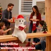 A family is decorating for Christmas, with a ghost-like statue holding a book as a centerpiece. Produktbild-Vorschau