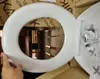 A person is holding a white toilet seat lid in a box. Podgląd zdjęcia produktu