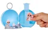 A hand is holding a small doll in front of an open blue toy sphere. Produktbild-Vorschau