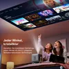 Two people, a mother and daughter, are looking up at a projected image on the ceiling, which displays movie posters. A projector is on a bed in the foreground. Produktbild-Vorschau