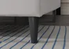 Close-up of the leg of a white bed on a rug. Náhľad obrázku produktu