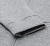 A close-up view of the cuff and zipper of a gray Nike sweatshirt. Anteprima dell’immagine prodotto