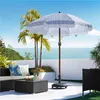 An outdoor patio scene with a striped umbrella, palm trees, and the ocean in the background. Produktbild-Vorschau