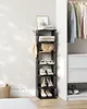 A black multi-tier shelf unit holding shoes, books, and a handbag, placed next to a closet with hanging clothes. Anteprima dell’immagine prodotto
