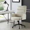 A beige office chair is placed next to a white desk with a black lamp and an open book. Produktbild-Vorschau