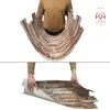 A person holding a flexible wall panel with a stone and wood mosaic pattern. The panel is curved in the top image and being unrolled in the bottom image. Produktbild-Vorschau