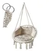 A macrame hanging chair with cushions, suspended by ropes and metal rings. Náhled obrázku produktu