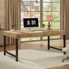 A wooden desk with a computer and lamp in a well-lit room with a large window. Voir les images du produit