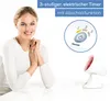 A woman is sitting at a table with an infrared lamp and a timer display shown. Produktbild-Vorschau