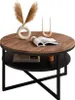 A round coffee table with a wooden top and black metal legs, decorated with a vase of dried flowers, a candle holder with candles, and an open book. Produktbild-Vorschau