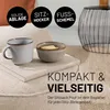 A close-up of a beige pouf with a mug and a bowl of crackers on top, with marketing text overlays. Podgląd zdjęcia produktu