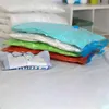 A stack of vacuum seal bags filled with items, including clothing and bedding, on a white surface. Voir les images du produit