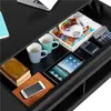 A close-up view of a drawer filled with various items, including books, mugs, a tablet, headphones, and a calculator. Produktbild-Vorschau