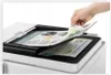 A hand is placing a document into a printer/scanner. Produktbild-Vorschau