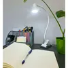 A desk setup with a lamp, notebook, pen, and office supplies. Náhled obrázku produktu