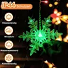 A hand holding a green LED snowflake light with other lights in the background. Náhled obrázku produktu