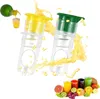Two manual juicers with juice splashing around them, with a selection of fruits and juices in the foreground. Produktbild-Vorschau