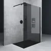 A modern bathroom shower enclosure with a black glass wall and black fixtures against a concrete wall. Produktbild-Vorschau