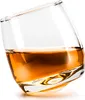A single glass of amber liquid, likely whiskey, tilted on a white background. Podgląd zdjęcia produktu