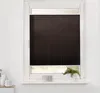 A dark brown pleated blind is installed in a white window frame. The blind is partially lowered, covering the top portion of the window. Below the blind, a small section of the window shows a blurred outdoor view. On the windowsill, there are two decorativ Produktbild-Vorschau
