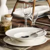 A table setting with plates, glasses, and a jar of pickles. Náhľad obrázku produktu