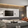 A modern living room with a large TV mounted on a marble accent wall, flanked by acoustic panels. Two orange armchairs are visible, along with a gray sofa and a patterned ottoman. Produktbild-Vorschau
