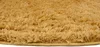 A close-up, angled view of a round, yellow-brown rug with a shaggy texture. Anteprima dell’immagine prodotto