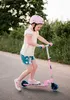 A young girl riding a pink scooter on a paved path. Produktbild-Vorschau