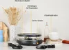 A raclette grill is shown on a countertop with decorative elements. Anteprima dell’immagine prodotto