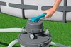 A hand is shown adjusting the valve on a pool filter system next to an above-ground swimming pool. Produktbild-Vorschau