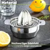 A stainless steel citrus juicer with a lemon and a glass on a dark countertop. Produktbild-Vorschau
