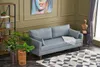 A living room scene with a blue sofa, a bookshelf, plants, and a rug. Produktbild-Vorschau