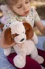 A young child holding a plush dog toy outdoors. Produktbild-Vorschau