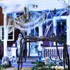 A spooky Halloween decoration scene on a porch, featuring a giant spider, ghosts, and cobwebs. Produktbild-Vorschau