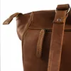 A close-up view of a brown leather bag. Voir les images du produit