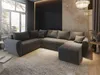A modern living room with a large sectional sofa, large windows, and decorative wall panels.