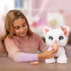 A young girl is playing with a white interactive toy cat. Anteprima dell’immagine prodotto