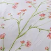 A close-up view of a white fabric with a floral pattern of pink flowers and green stems. Produktbild-Vorschau