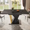 A dining table with a marble-like top and a geometric base, set in a well-lit room with large windows and chairs. Produktbild-Vorschau