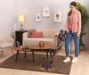 A woman is vacuuming a rug in a living room. Voir les images du produit