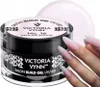 A jar of Victoria Vynn Salon Build Gel UV/LED in Delicate Rouge No. 16, with a hand displaying the gel applied to nails in the foreground. Náhled obrázku produktu