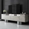 A modern TV stand with marble-like finish and silver cylindrical legs, displaying a large flat-screen TV and decorative items. Voir les images du produit