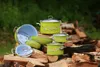 A set of green enamel pots with daisy decorations are arranged on a pile of firewood outdoors. Náhľad obrázku produktu