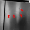 A close-up view of a dark, possibly metallic surface with several red arrows pointing to small imperfections or marks. Produktbild-Vorschau
