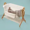 A baby sleeping in a bedside crib with a teddy bear and a blanket. Náhled obrázku produktu